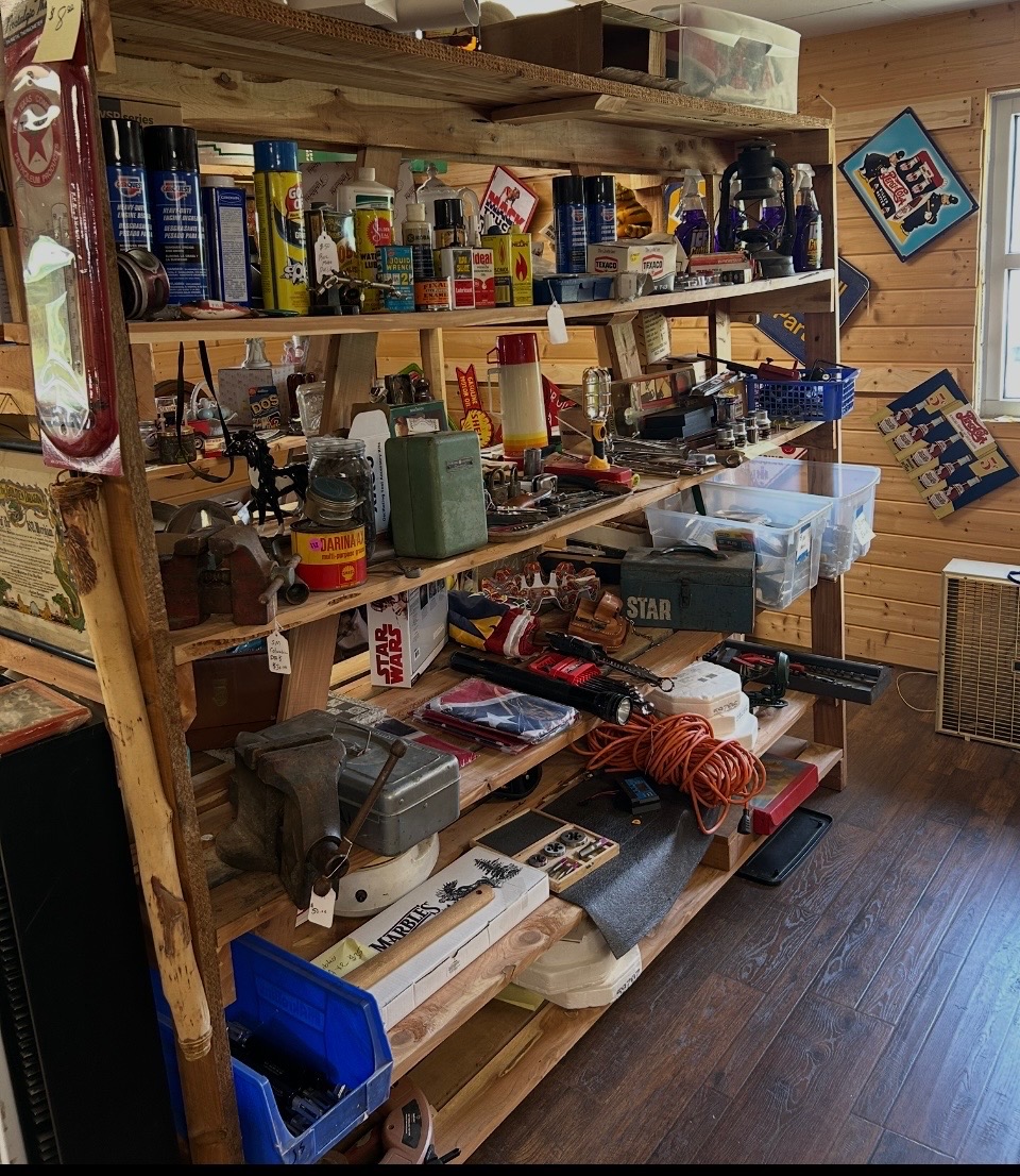Shelves stocked with vintage oil cans, signs, and tools