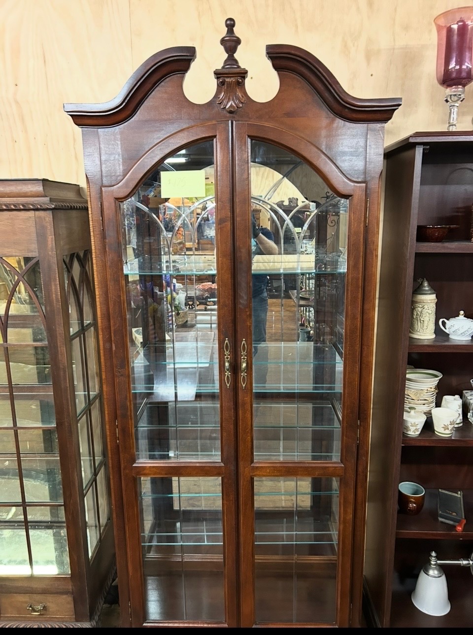 Mahogany lighted curio cabinet with arched broken pediment top